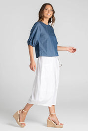 A model wearing the Guru Skirt in colour White (White), from the front, showing the whole outfit