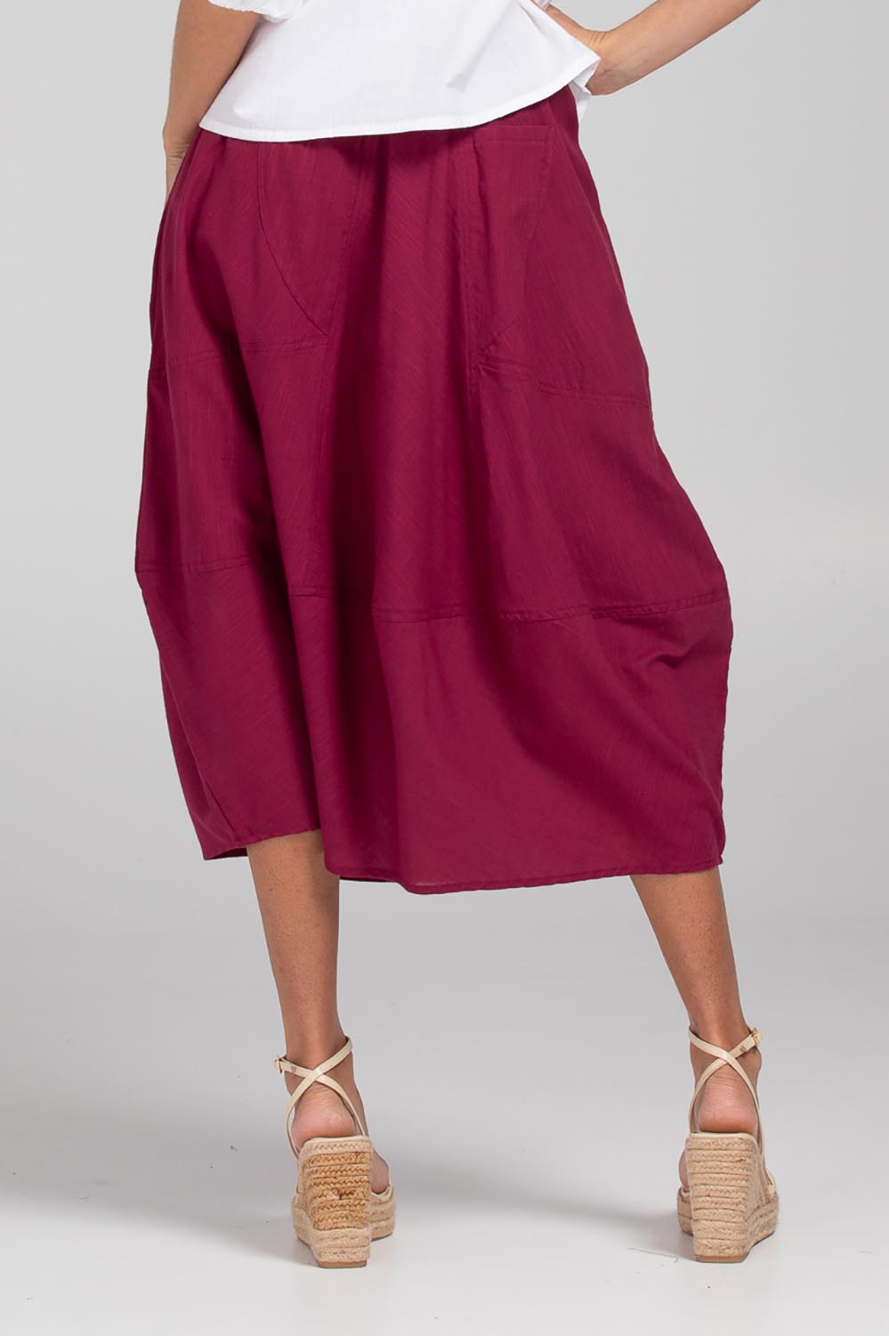 A model wearing the Guru Cotton Skirt in colour Magenta (Purple), from the back