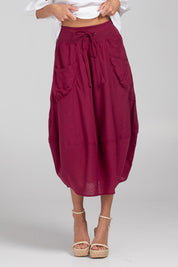 A model wearing the Guru Cotton Skirt in colour Magenta (Purple), from the front, cropped image