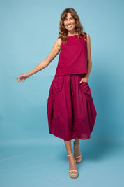 A model wearing the Guru Cotton Skirt in colour Magenta (Purple), from the front, showing the whole outfit