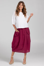A model wearing the Guru Cotton Skirt in colour Magenta (Purple), from the front, showing the whole outfit