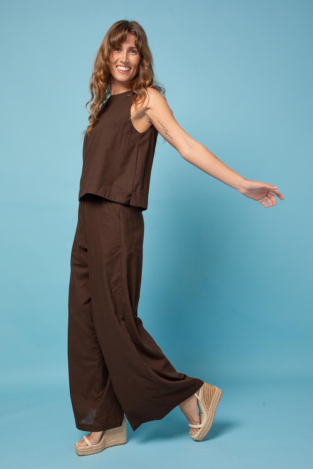 A model wearing the Luca Cotton Pant in colour Coffee, from the front, showing the whole outfit