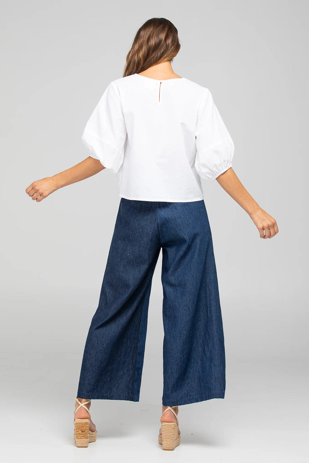 A model wearing the Ria Denim Pant in colour Darkdenim (Blue), from the back
