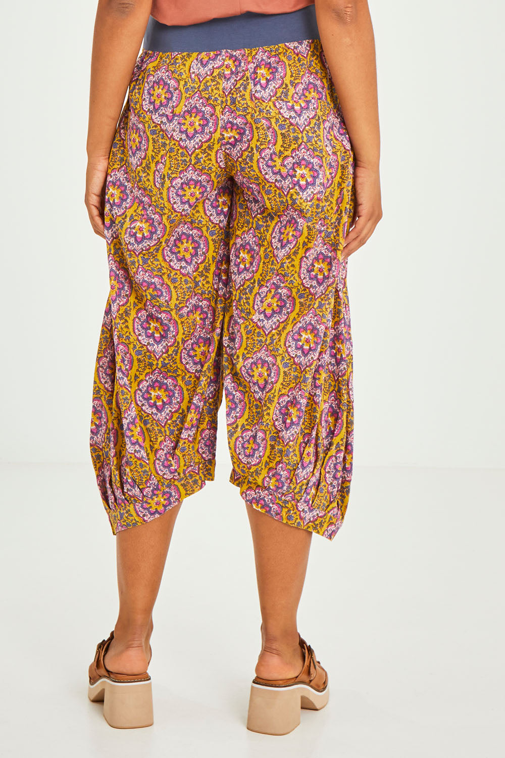 Model Olivia wearing size 10 of the Guru Pant in colour Amaira, from the back