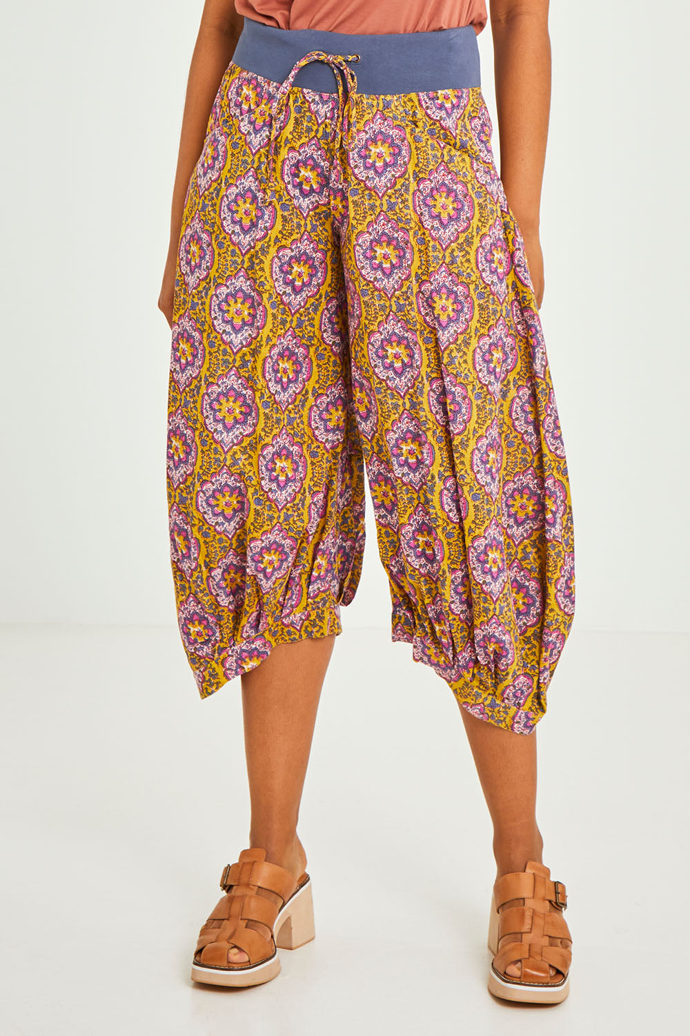 Model Olivia wearing size 10 of the Guru Pant in colour Amaira, from the front, cropped image