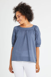 Model Olivia wearing size 10 of the Bliss Top in colour Indiansea (Blue), from the front, cropped image