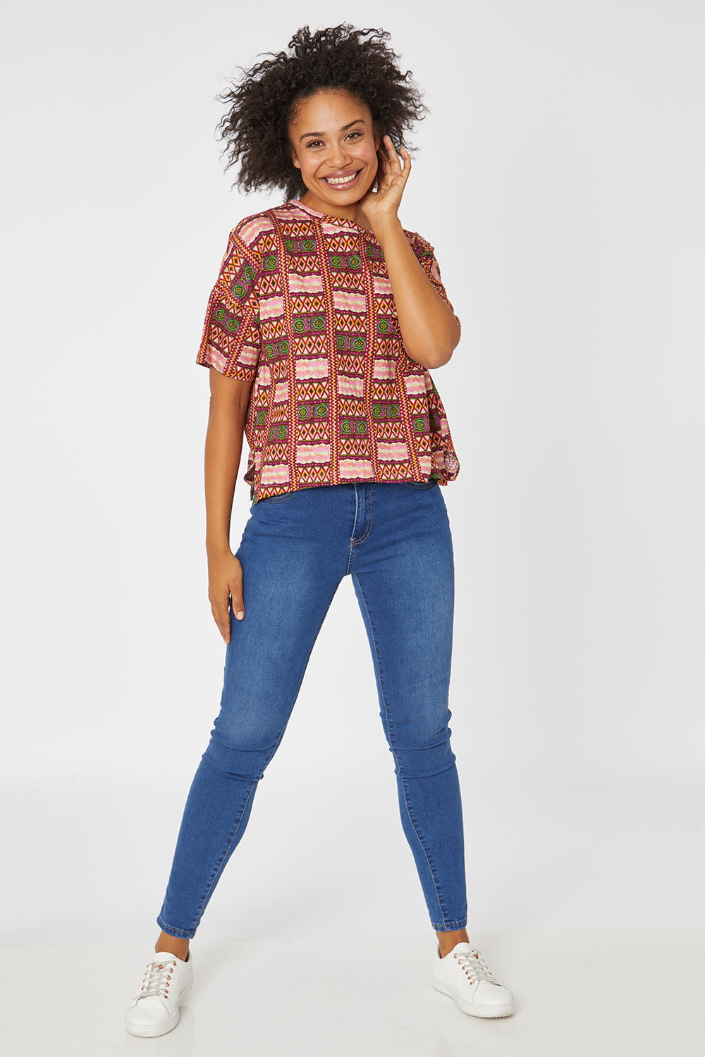 Model Olivia wearing size 10 of the Holi Tee in colour Holi (Pink), from the front, showing the whole outfit