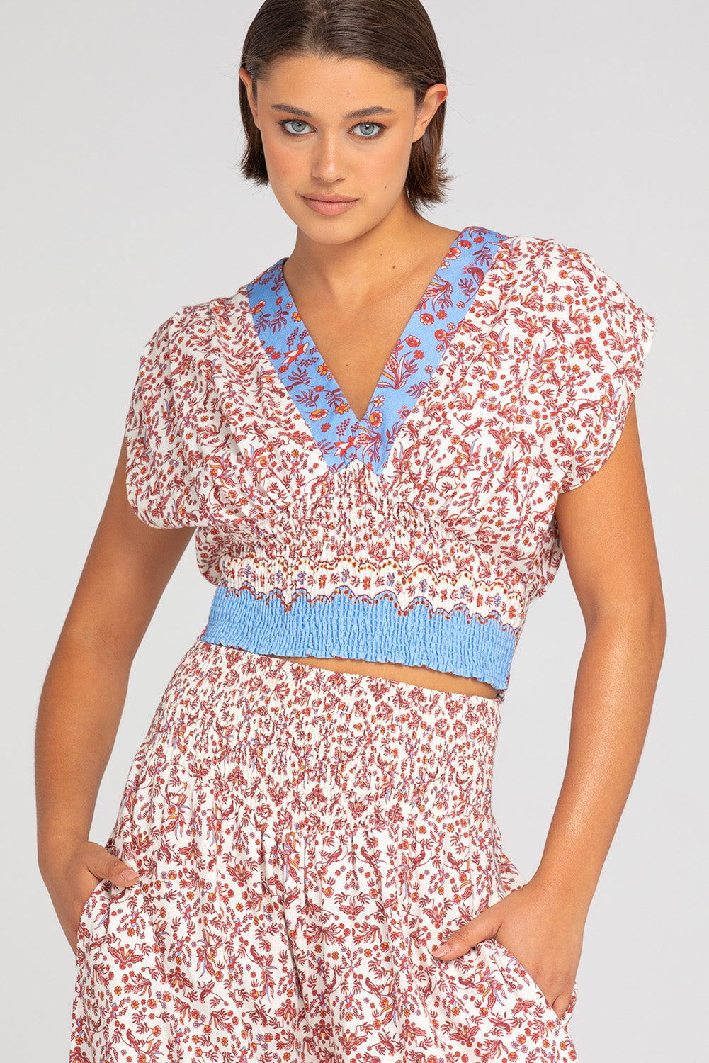 A model wearing the Desi Cotton Top in colour Paradise, from the front, cropped image
