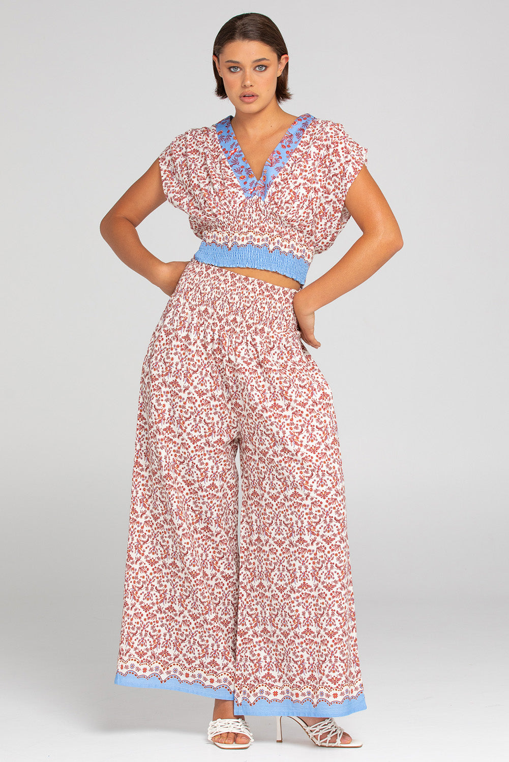 A model wearing the Desi Cotton Top in colour Paradise, from the front, showing the whole outfit