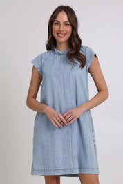 Model Madeline wearing size 10 of the Sand Lyocell Dress in colour Comoda (Blue), from the front, cropped image