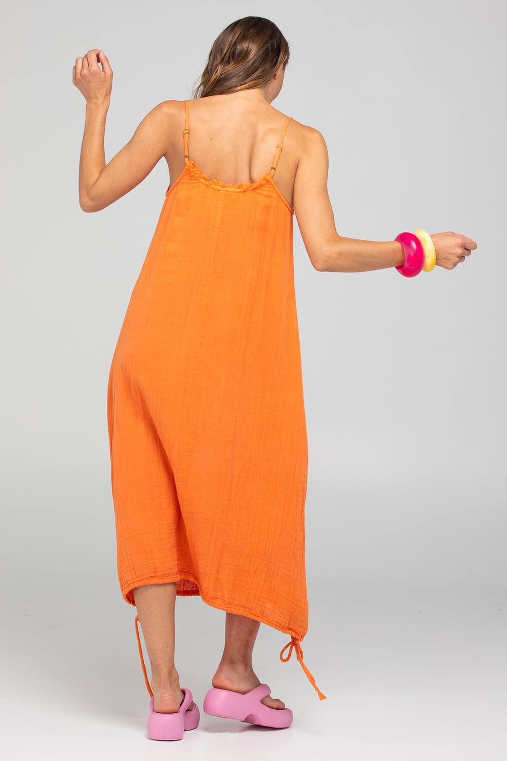 A model wearing the Arena Cotton Dress in colour Tangerine, from the back