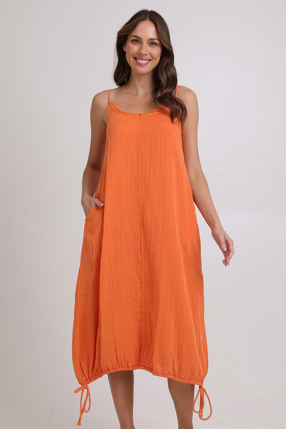 Model Madeline wearing size 10 of the Arena Cotton Dress in colour Tangerine, from the front, showing the whole outfit