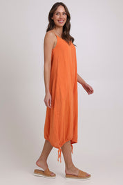 Model Madeline wearing size 10 of the Arena Cotton Dress in colour Tangerine, from the front, showing the whole outfit
