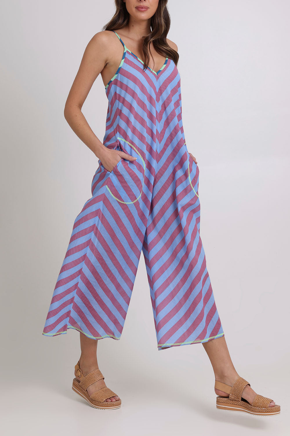 Model Madeline wearing size 10 of the Shimmi Cotton Jumpsuit in colour Capriblue (Blue), from the front, cropped image