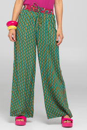 A model wearing the Harper Pant in colour Celaya (Green), from the front, cropped image