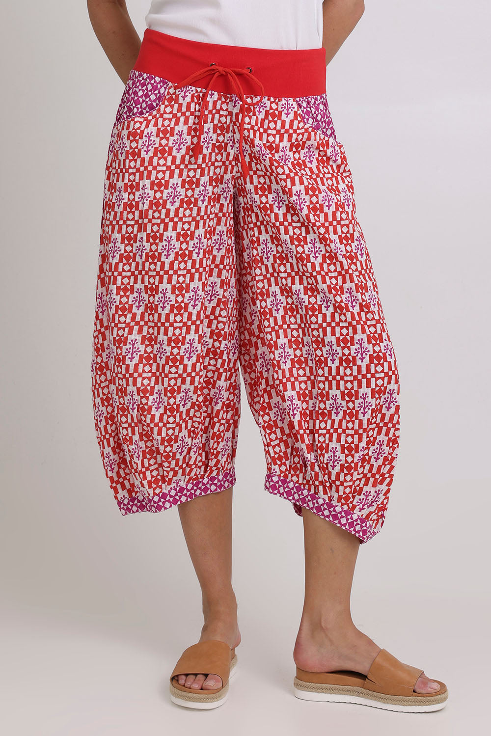 Model Madeline wearing size 10 of the Guru Cotton Pant in colour Naples (Pink), from the front, cropped image