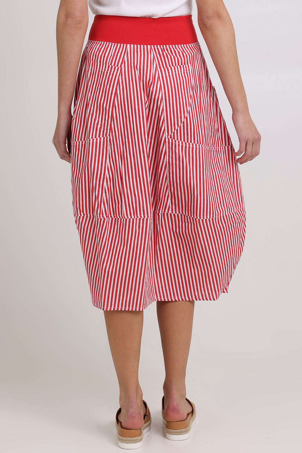 Model Madeline wearing size 10 of the Guru Cotton Skirt in colour Emilias (Red), from the back
