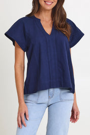 Model Madeline wearing size 10 of the Livy Cotton Top in colour Navy (Blue), from the front, cropped image