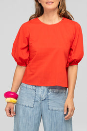 A model wearing the Ava Cotton Top in colour Pomodoro (Red), from the front, cropped image