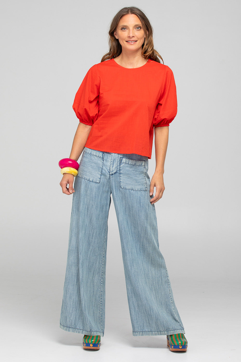 A model wearing the Ava Cotton Top in colour Pomodoro (Red), from the front, showing the whole outfit