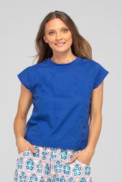 A model wearing the Leaf Cotton Top in colour Blu (Blue), from the front, cropped image
