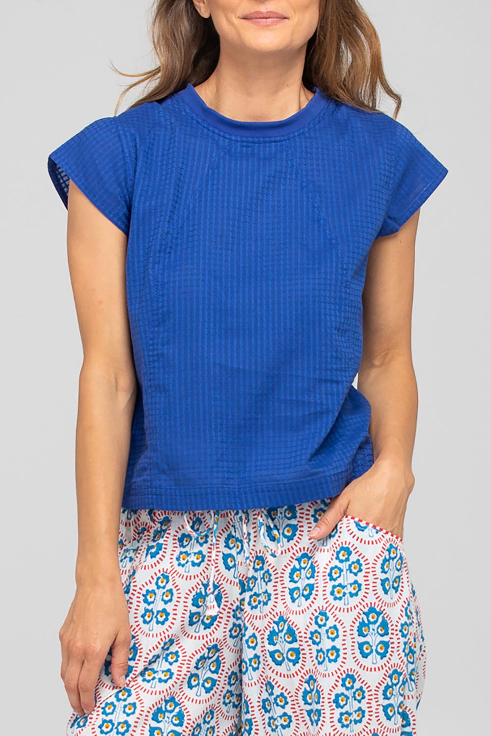 A model wearing the Leaf Cotton Top in colour Blu (Blue), from the front, cropped image