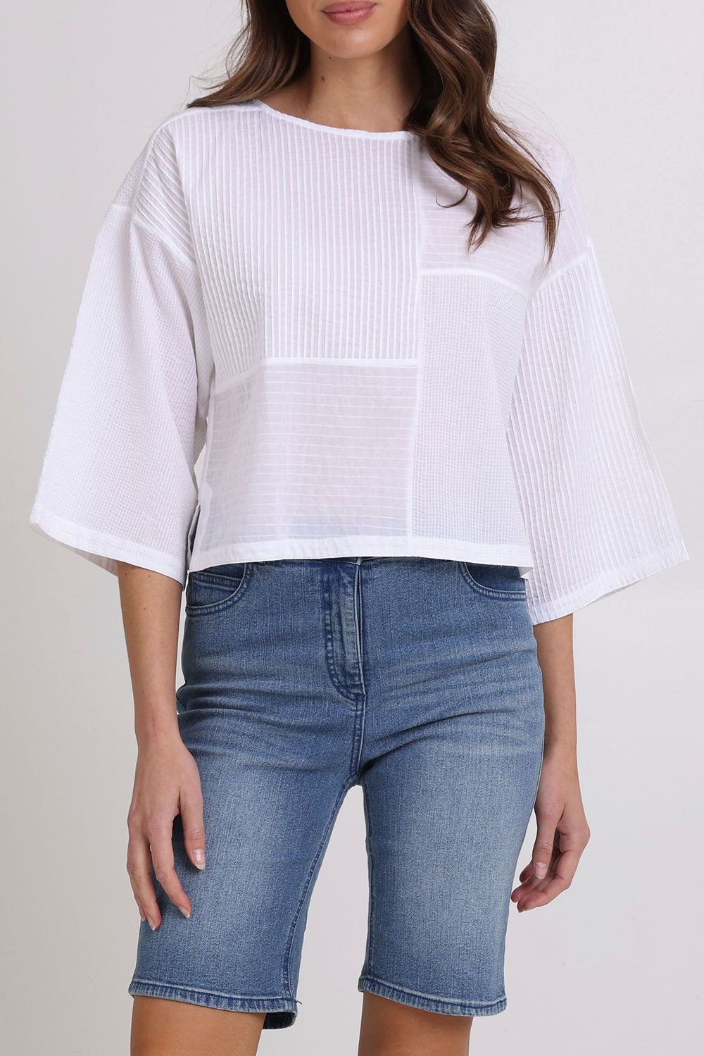 Model Madeline wearing size 10 of the Dimple Cotton Top in colour White (White), from the front, cropped image