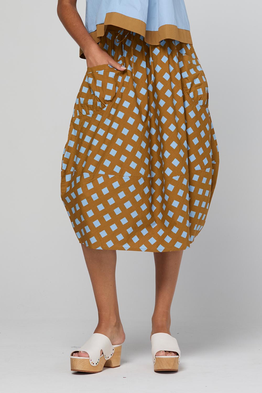 Model Genericm wearing size sample of the Guru Skirt – Geocheck in colour Geocheck, from an angle