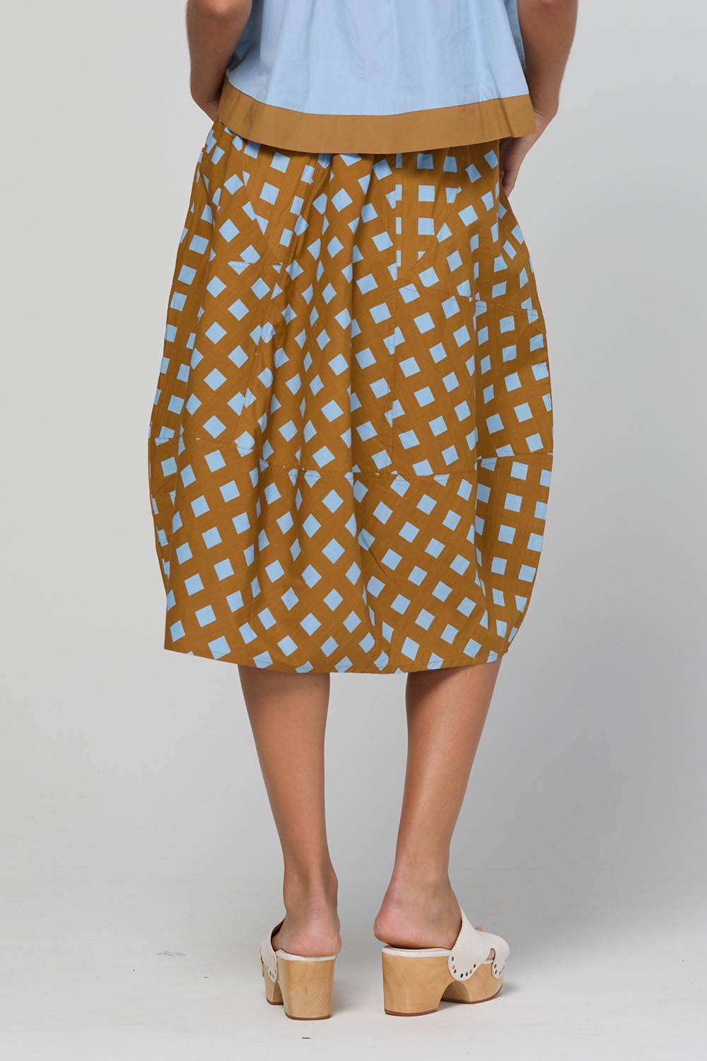 Model Genericm wearing size sample of the Guru Skirt – Geocheck in colour Geocheck, from the back