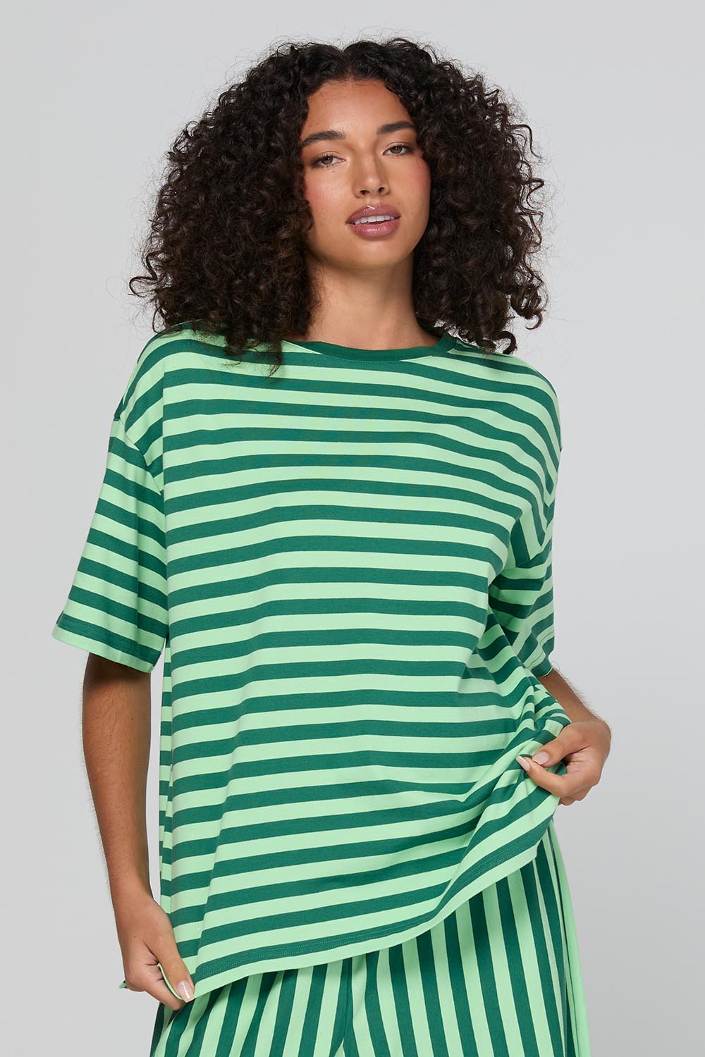 Model Genericm wearing size sample of the Luka Tee – Kiwi in colour Kiwi, in a cropped view