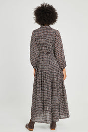 Model Olivia wearing size 10 of the Magari Dress in colour Allora (Black), from the back