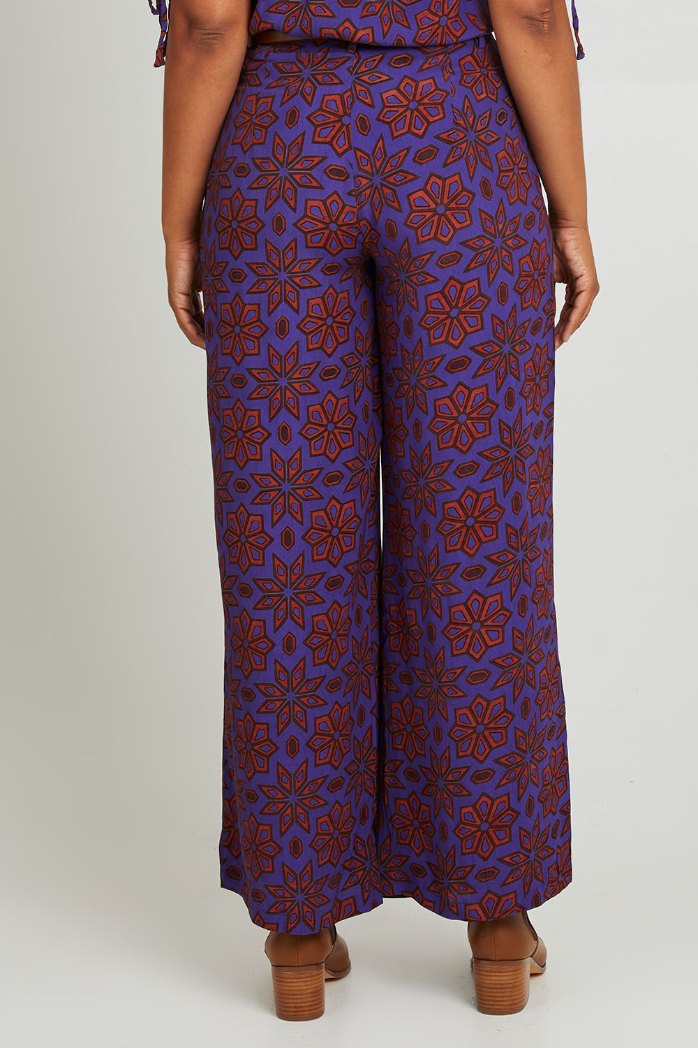 Model Olivia wearing size 10 of the Sara Pant in colour Rio (Purple), from the back