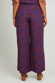 Model Olivia wearing size 10 of the Sara Pant in colour Rio (Purple), from the back