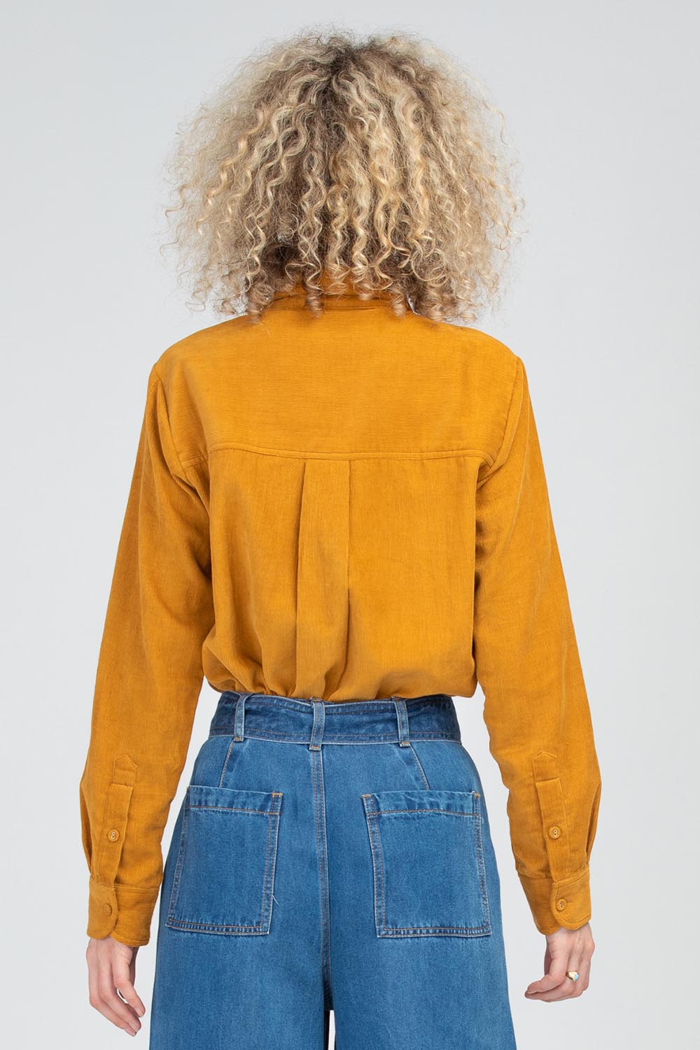 A model wearing the Metropolitan Cotton Cord Shirt in colour Marigold, from the back