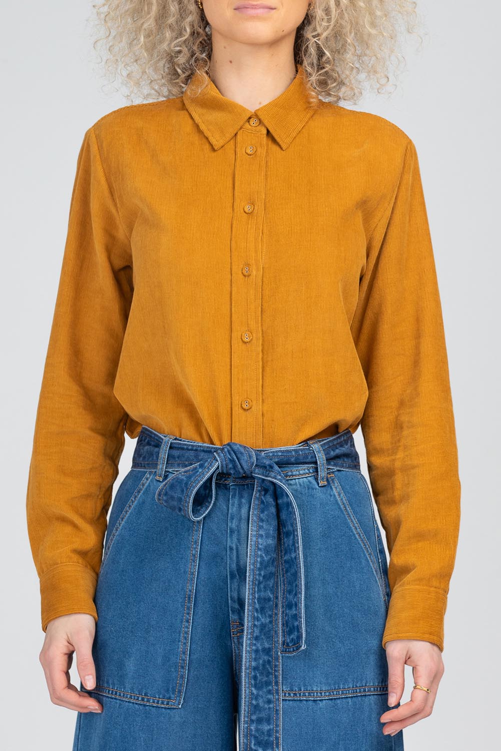 A model wearing the Metropolitan Cotton Cord Shirt in colour Marigold, from the front, cropped image