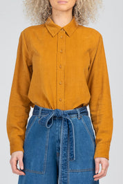 A model wearing the Metropolitan Cotton Cord Shirt in colour Marigold, from the front, cropped image