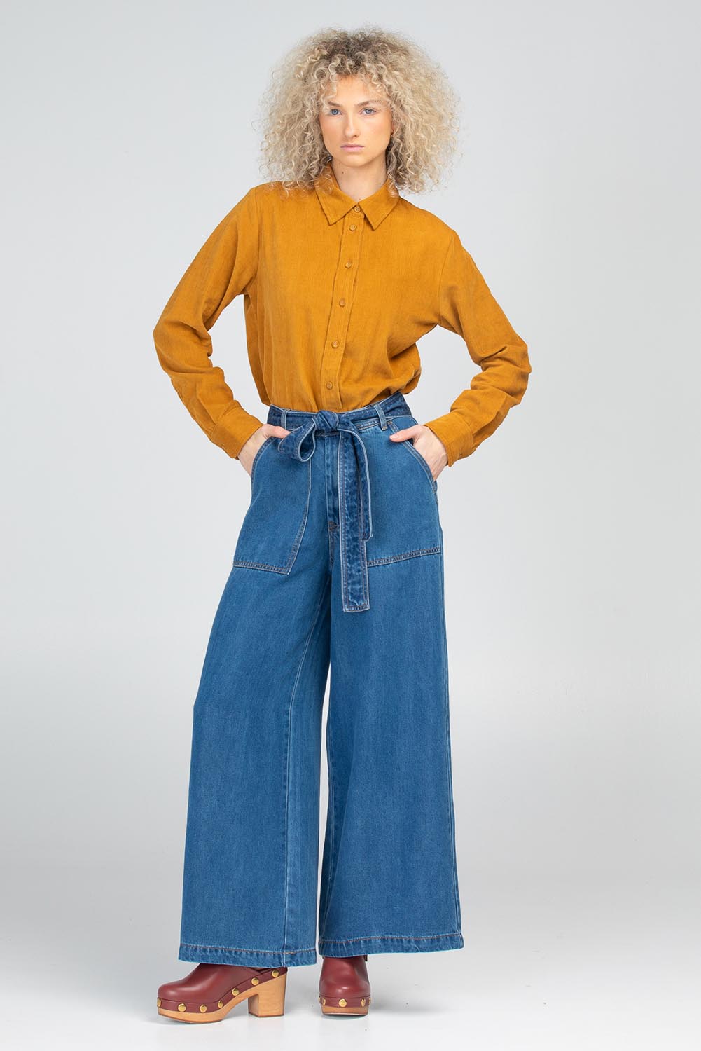 A model wearing the Metropolitan Cotton Cord Shirt in colour Marigold, from the front, showing the whole outfit