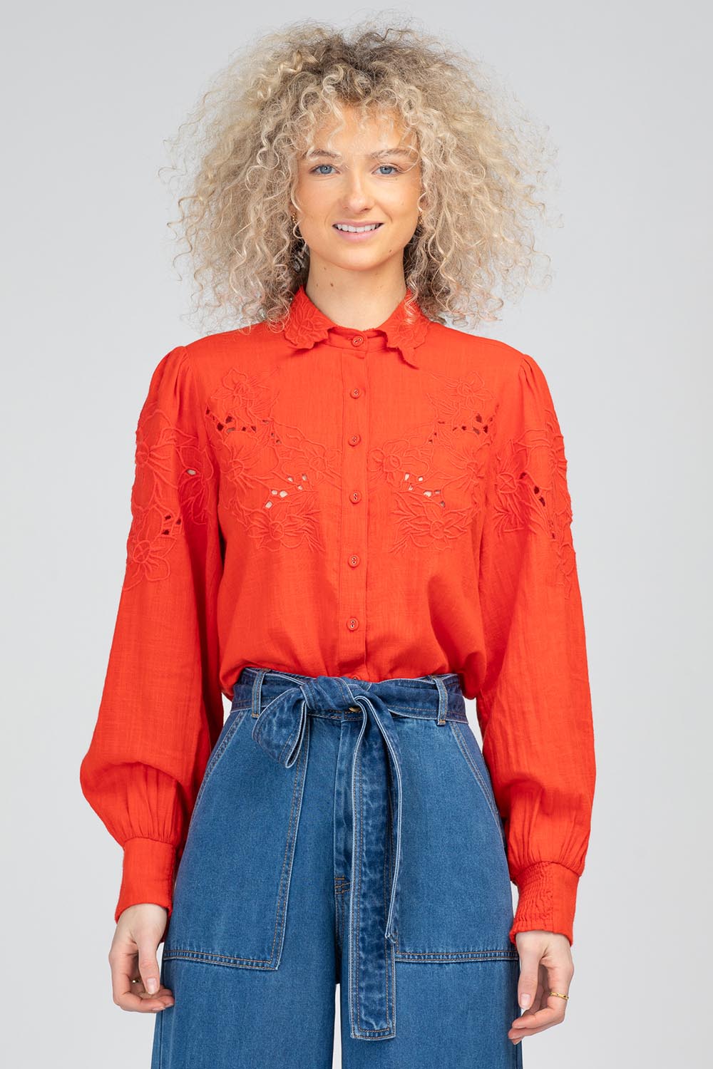A model wearing the Clementine Cotton Shirt in colour Poppyred (Red), from the front, cropped image