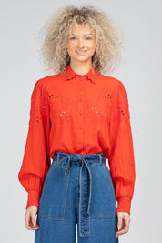 A model wearing the Clementine Cotton Shirt in colour Poppyred (Red), from the front, cropped image