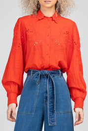 A model wearing the Clementine Cotton Shirt in colour Poppyred (Red), from the front, cropped image