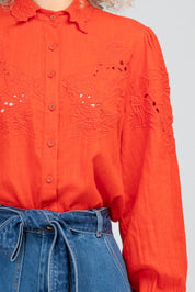 A model wearing the Clementine Cotton Shirt in colour Poppyred (Red), from the front, cropped image