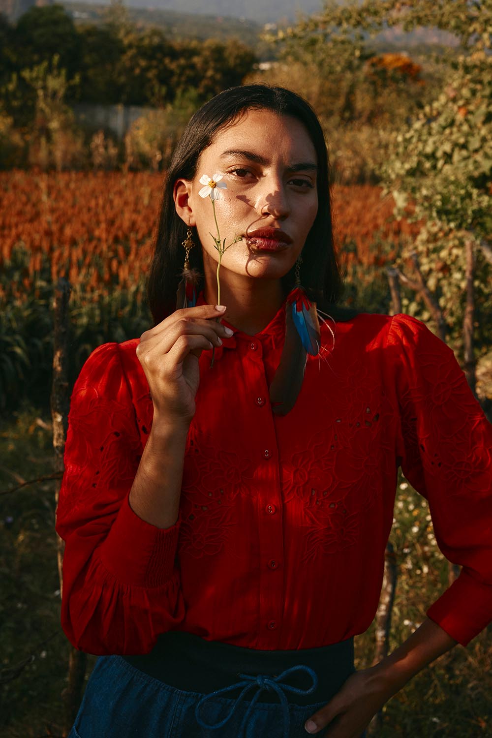 A model wearing the Clementine Cotton Shirt in colour Poppyred (Red), from the front, showing the whole outfit
