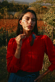 A model wearing the Clementine Cotton Shirt in colour Poppyred (Red), from the front, showing the whole outfit