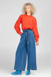 A model wearing the Clementine Cotton Shirt in colour Poppyred (Red), from the front, showing the whole outfit
