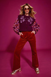 A model wearing the Dharma Pant in colour Cranberry (Red), from the front, showing the whole outfit