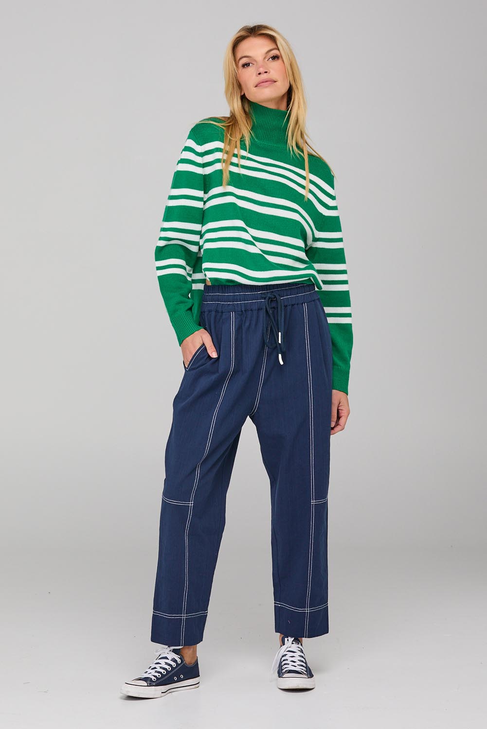 A model wearing the Jonte Pant in colour Navy (Blue), from the front, showing the whole outfit