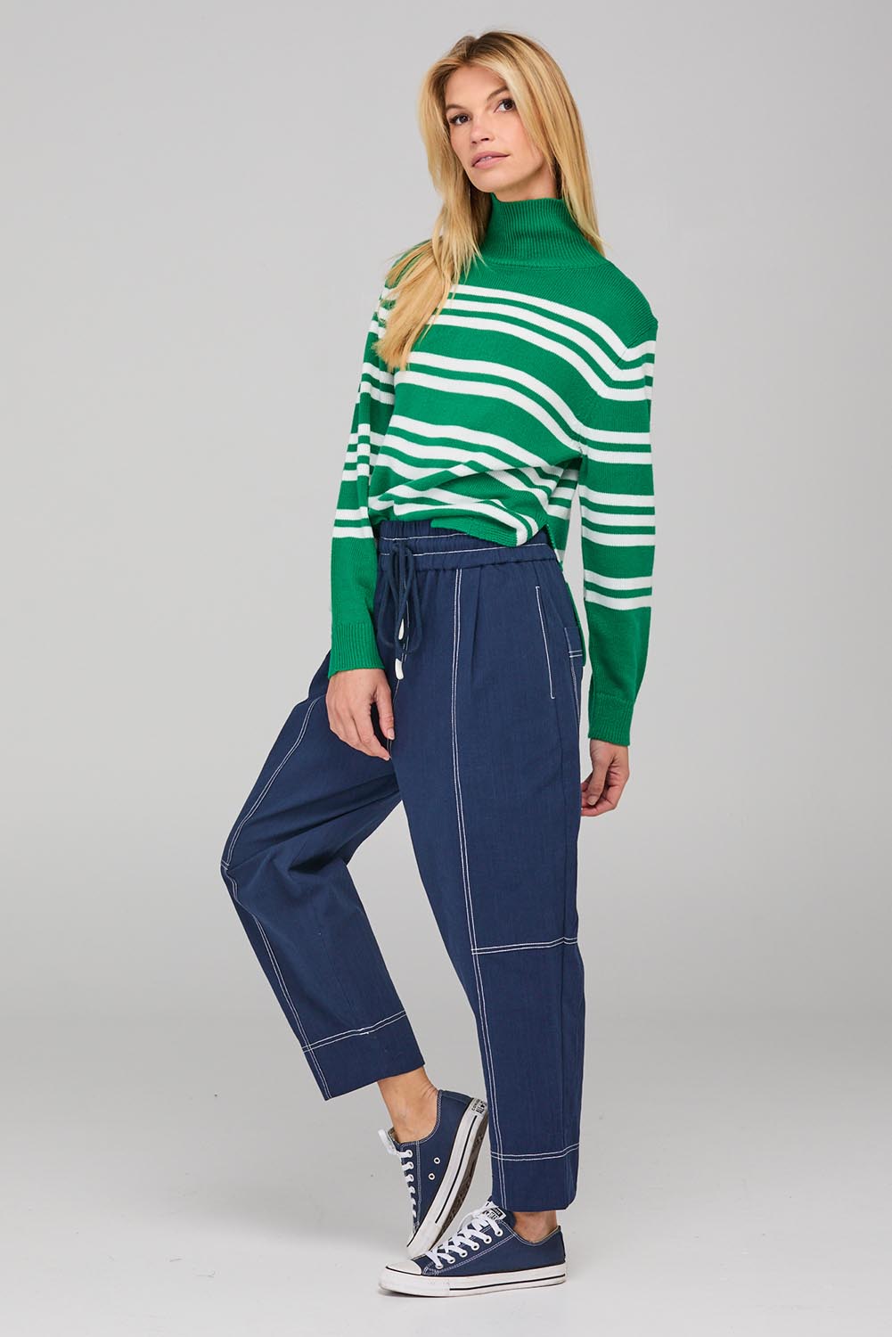 A model wearing the Jonte Pant in colour Navy (Blue), from the front, showing the whole outfit