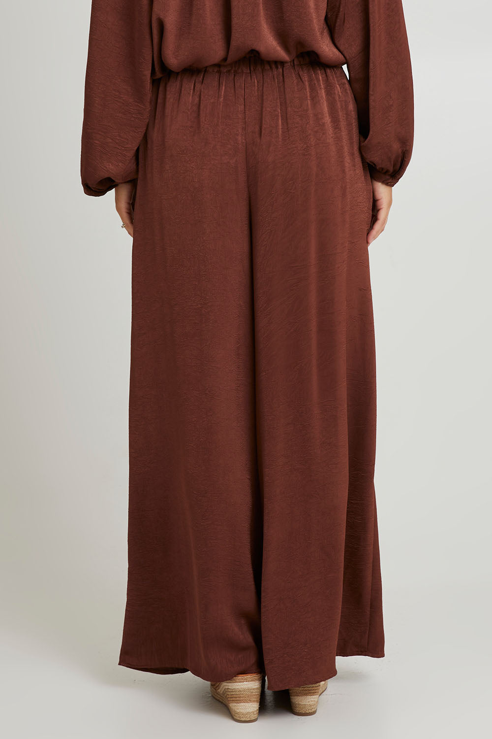 Model Katie wearing size S of the Liza Pant in colour Cocoa, from the back