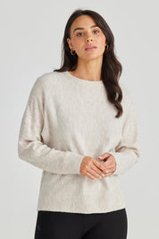 A model wearing the Saintly Knit in colour Parchment, from the front, cropped image