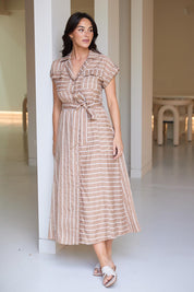 A model wearing the Portia Dress in colour Lattestrip, from the front, showing the whole outfit